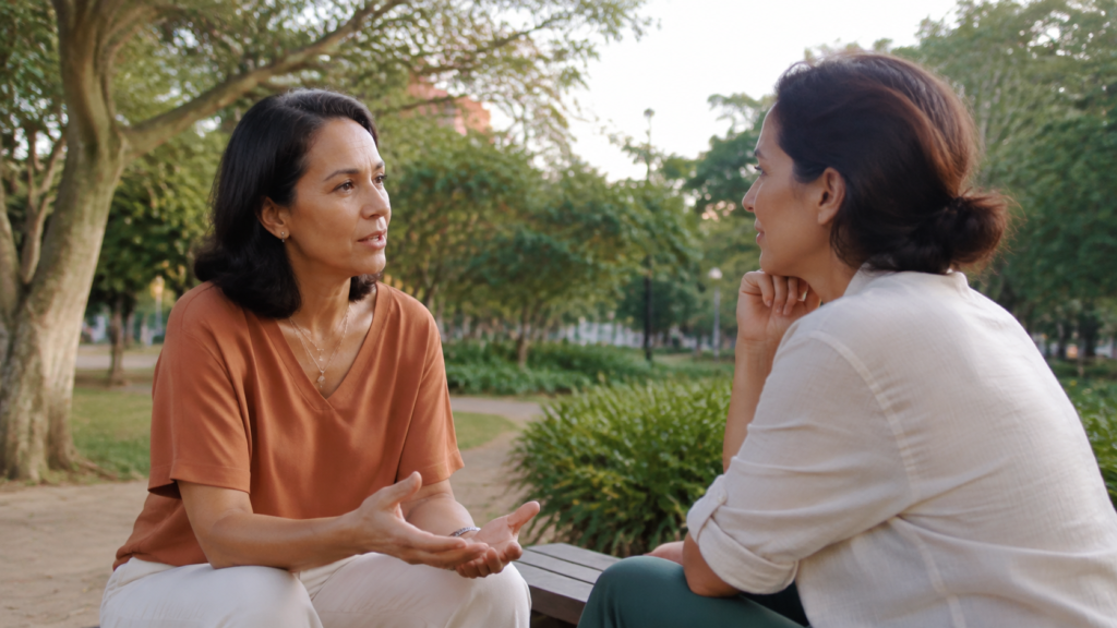 Duas mulheres conversando com respeito ao ar livre, representando limites saudáveis e autenticidade